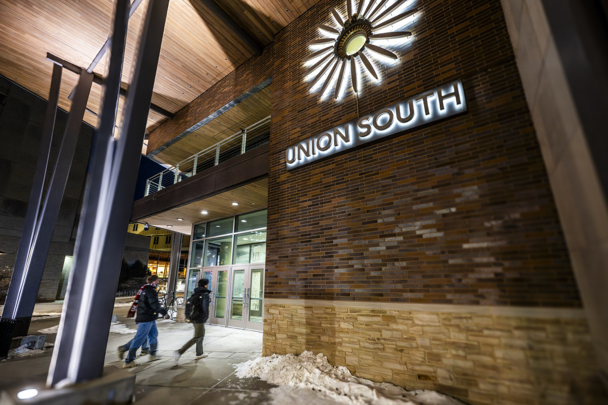 People enter a building with a sign that says "Union South."