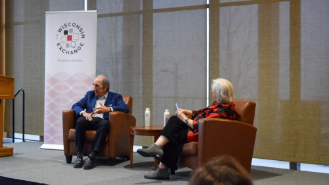 Two speakers, Andy Lack and Kathleen Bartzen Culver, sit on chairs on a stage in conversation, in front of a 