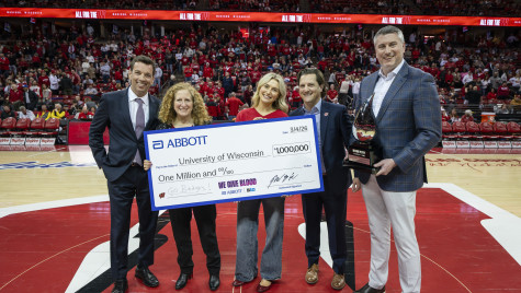 UW leaders accept a giant check at midcourt of the Kohl Center.
