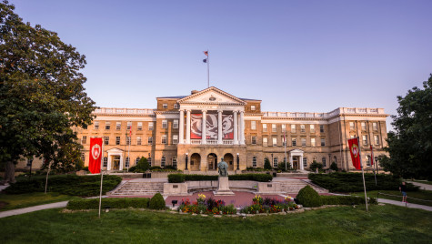 A drone shot of Bascom Hall at dusk, with branded banners and the Abe Lincoln statue in the foreground.