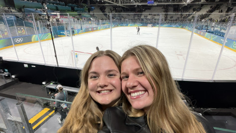 UW student Delaney Kuny and a friend smile for a selfie in front of an Olympic hockey rink.