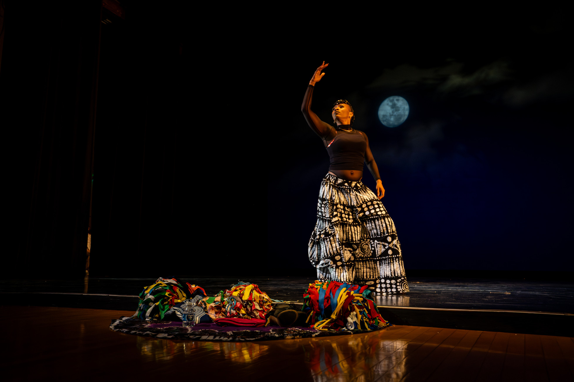 Stacy Letrice wears a black and white costume and poses on stage before a dance number.