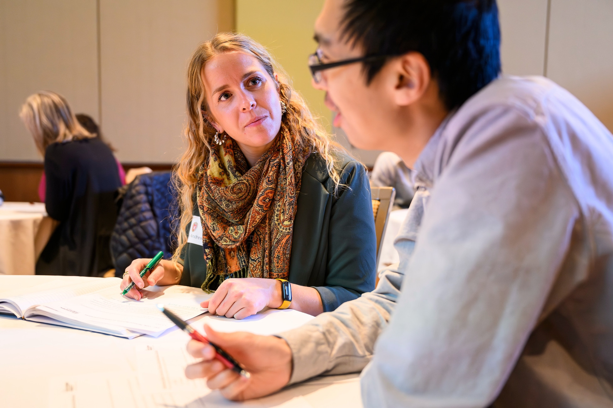 Two workshop participants talking at a table