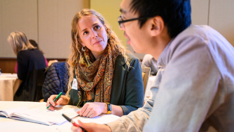 Two workshop participants talking at a table