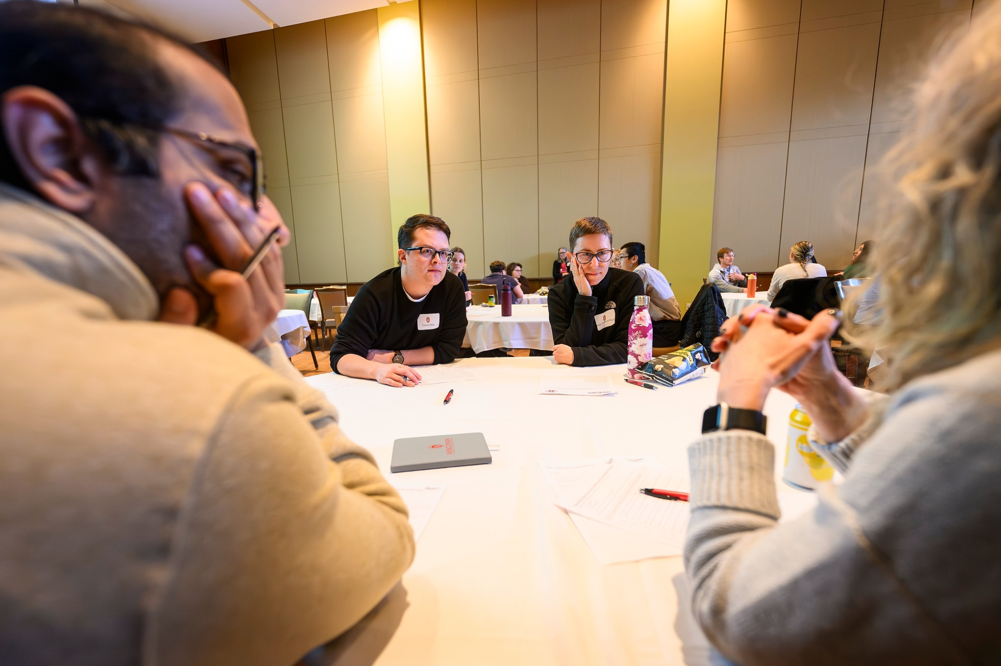 Group of four people at a workshop table having a discussion