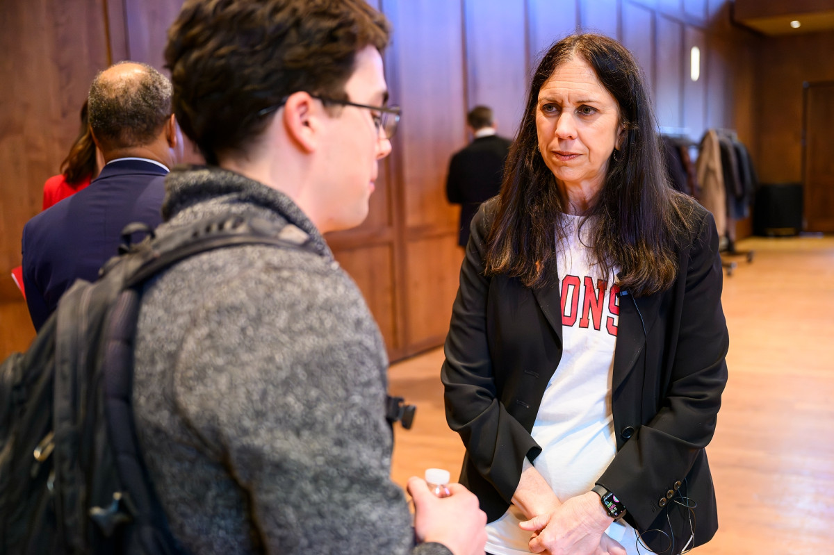 Colleen Shogan speaking with a student in a large event hall