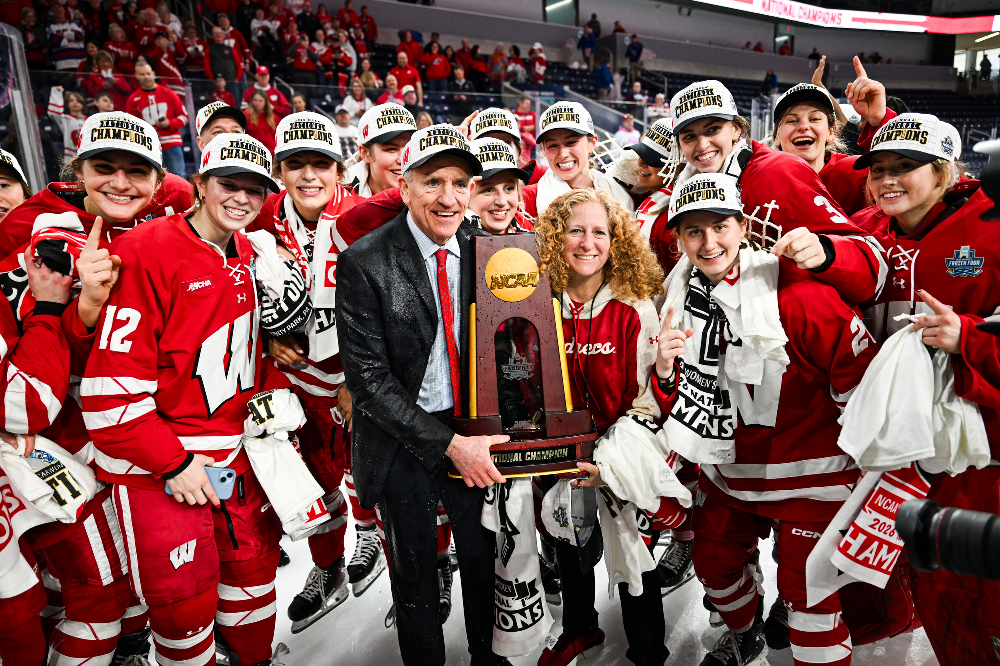 Members of the Badger women’s hockey team, coach Mark Johnson and Chancellor Mnookin pose together with the NCAA championship trophy
