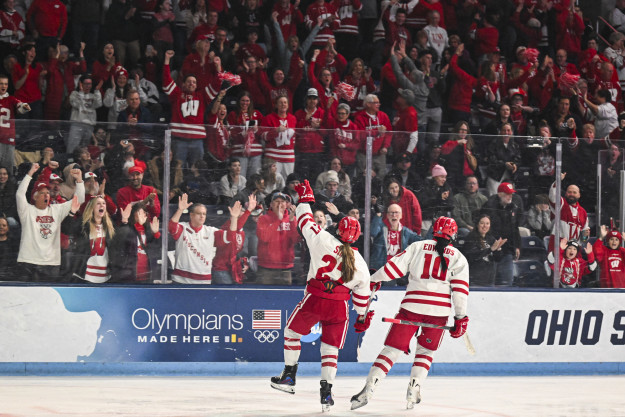 From the ice, players Kirsten Simms and Laila Edwards acknowledge the Badger fans in the stands after Edwards scored a goal.