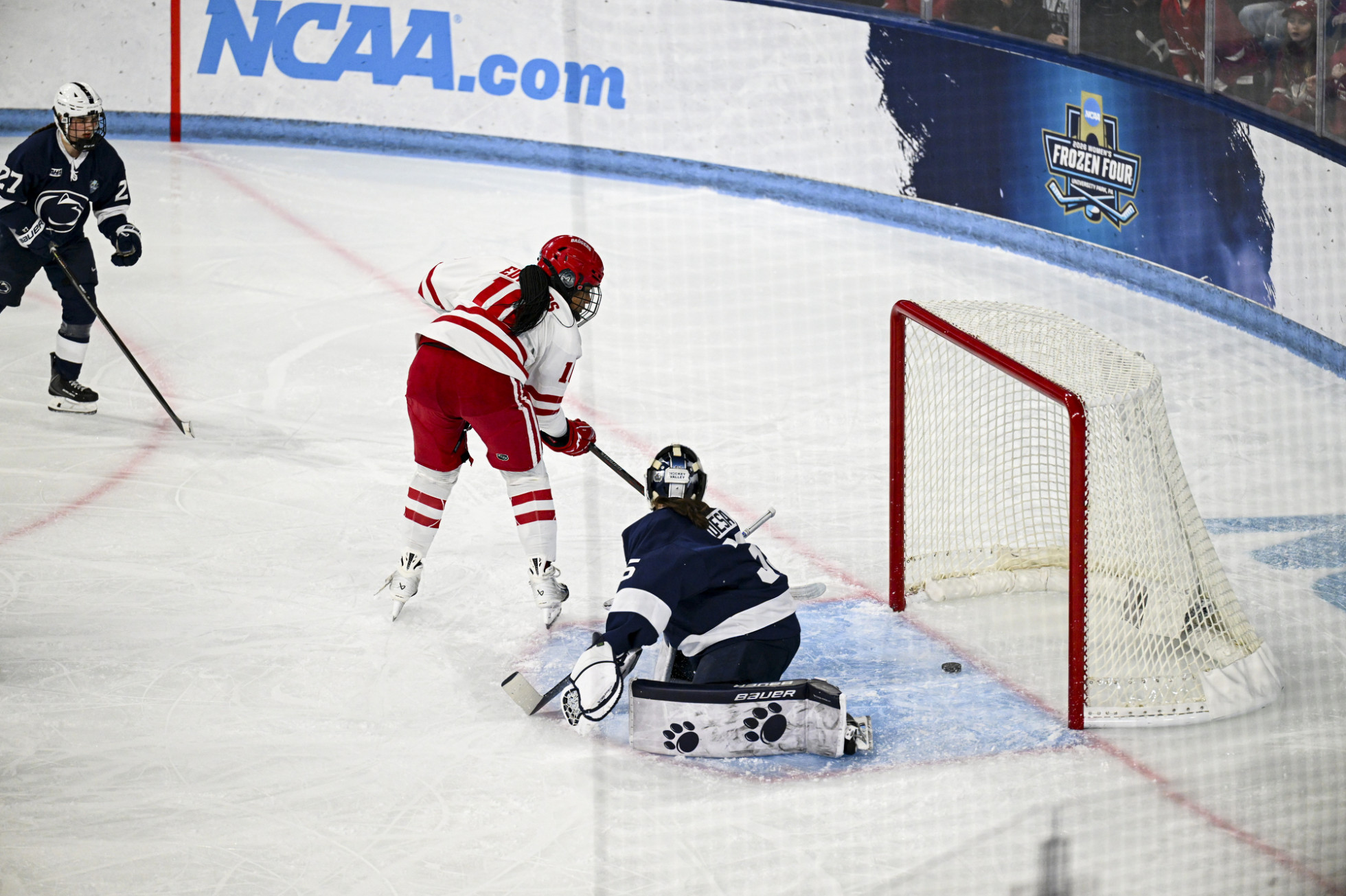 Laila Edwards skates toward the Penn State goal and pushes the hockey puck past the Nittany Lions goalkeeper to score a goal. 