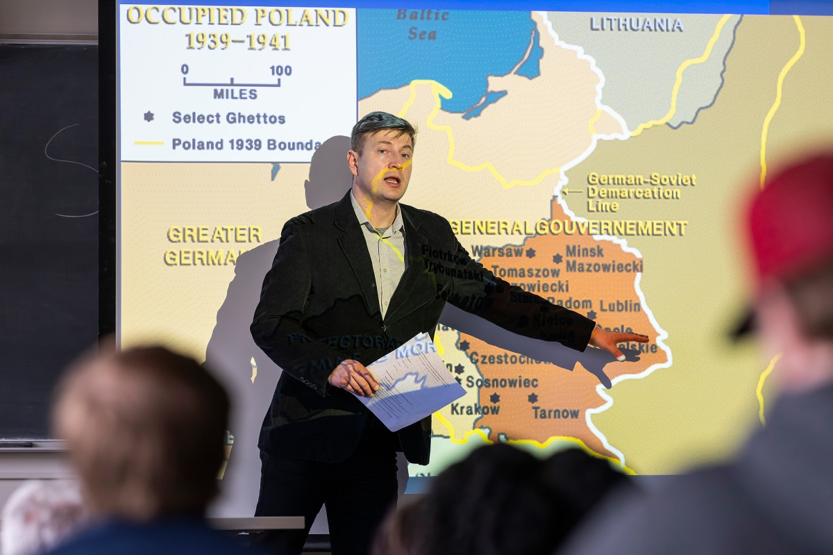 Lukasz Wodzynski stands at the head of a classroom and points out key parts of a map of Poland from 1939-1941.