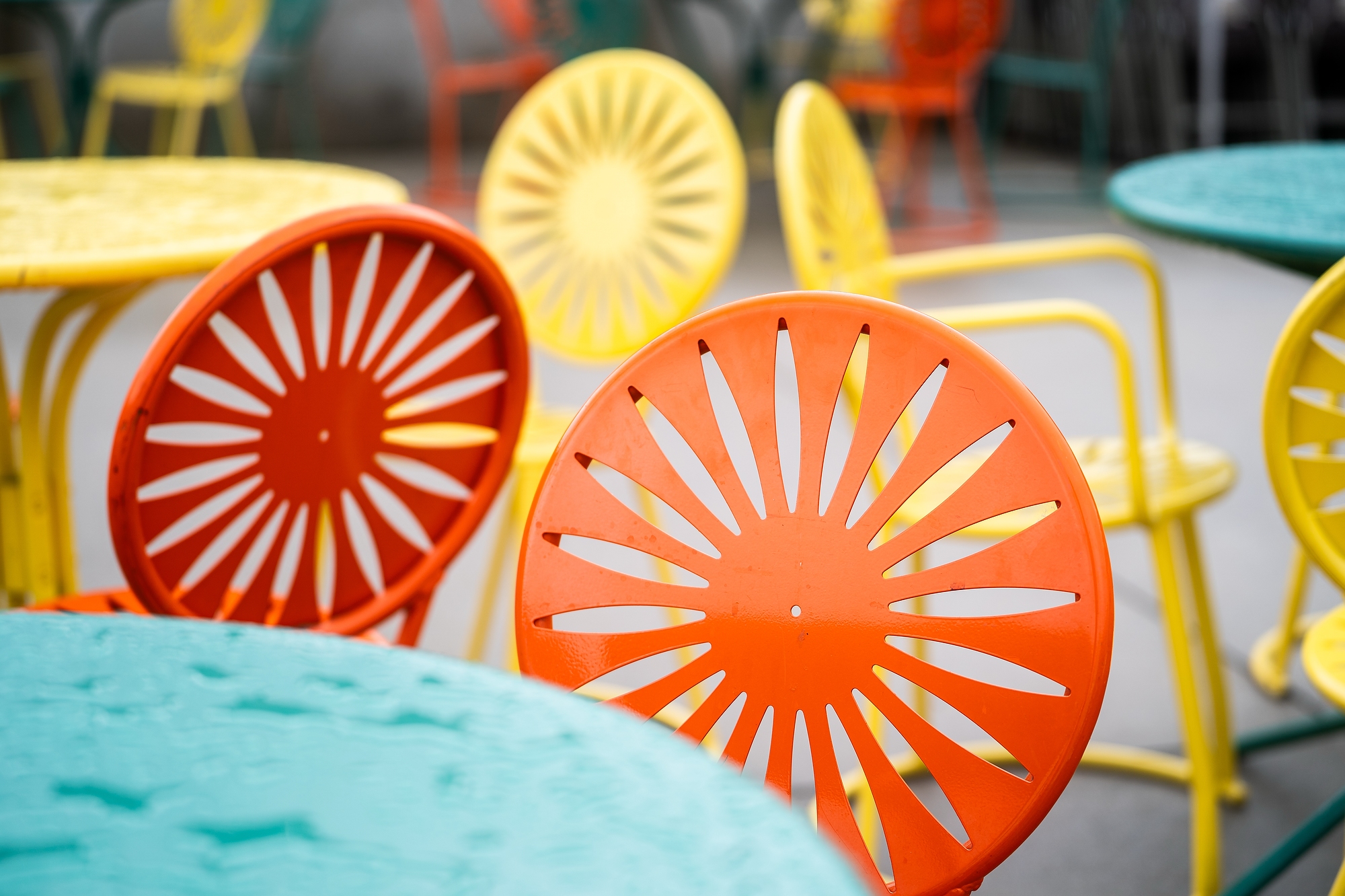 A close-up of orange, red and yellow sunburst chairs at the Memorial Union Terrace.