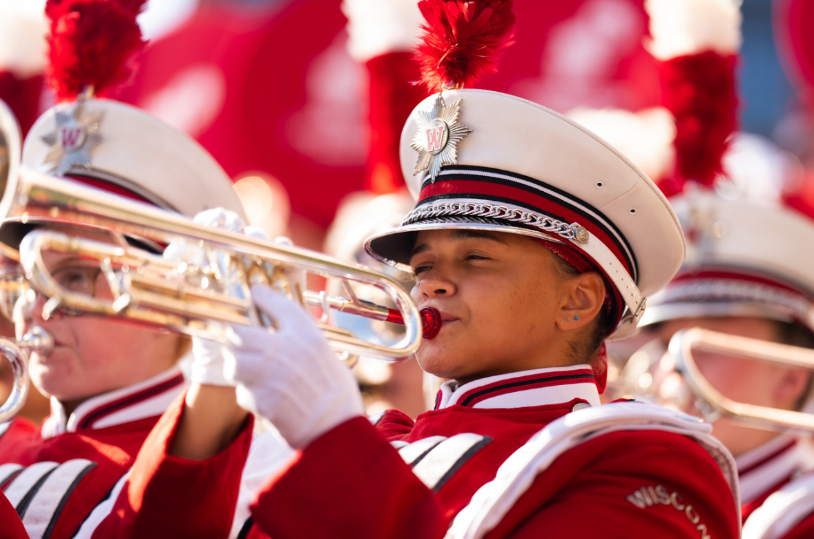 A closeup of a trumpet player wearing UW Marching Band gear