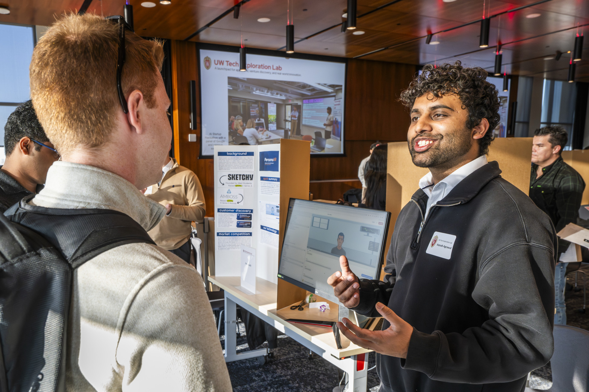 A student smiles as he explains his research.