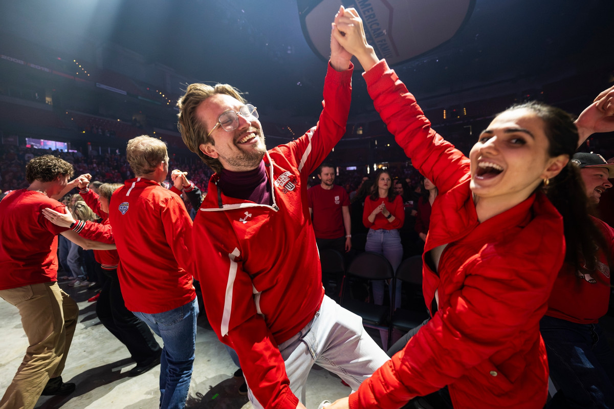 Two fans wearing Badger red attire dance the polka during one of the songs.