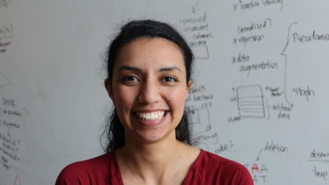 Portrait of Claudia Solís-Lemus in front of a whiteboard with academic drawings.