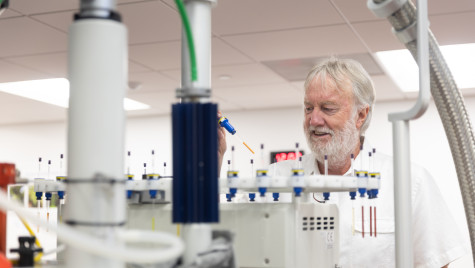Professor John Ralph works with lab equipment at the Wisconsin Energy Institute.