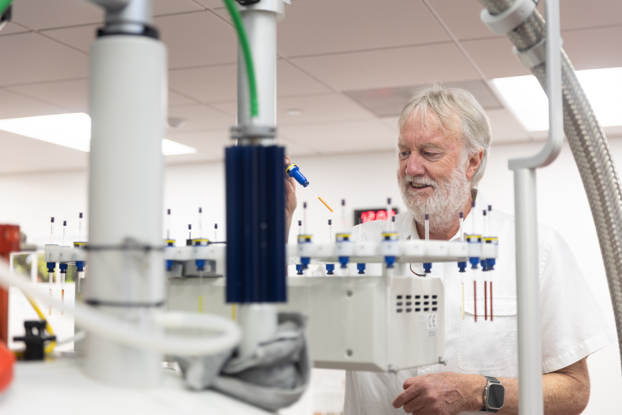 Professor John Ralph works with lab equipment at the Wisconsin Energy Institute.