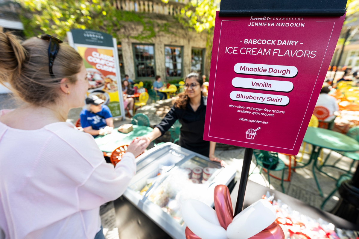 A sign shows the three options of free ice cream available for event attendees. One flavor includes Mnookie Dough, which was made in honor of Chancellor Mnookin.