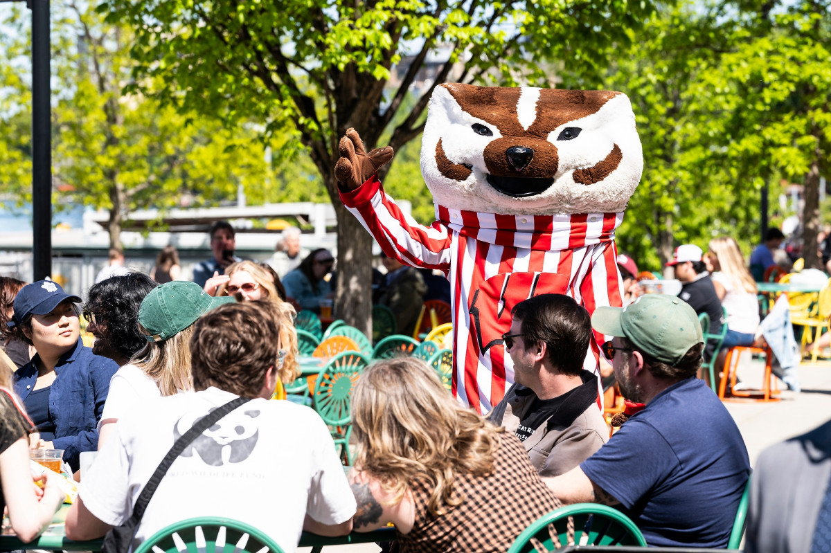 Mascot Bucky Badger interacts with a group of event guests seated in Terrace chairs.