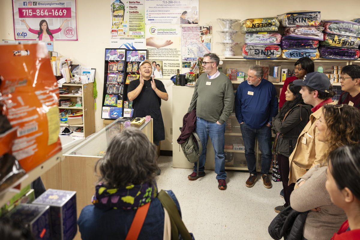 Inside an international food store, Moua talks to a group visiting the shop.