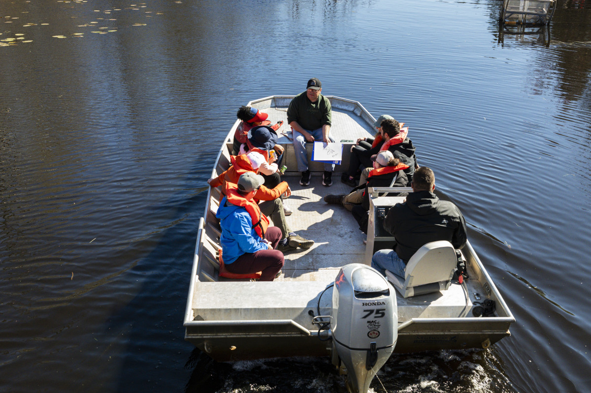Members of a group tour sit in a boat while getting a water tour of the sloughs.
