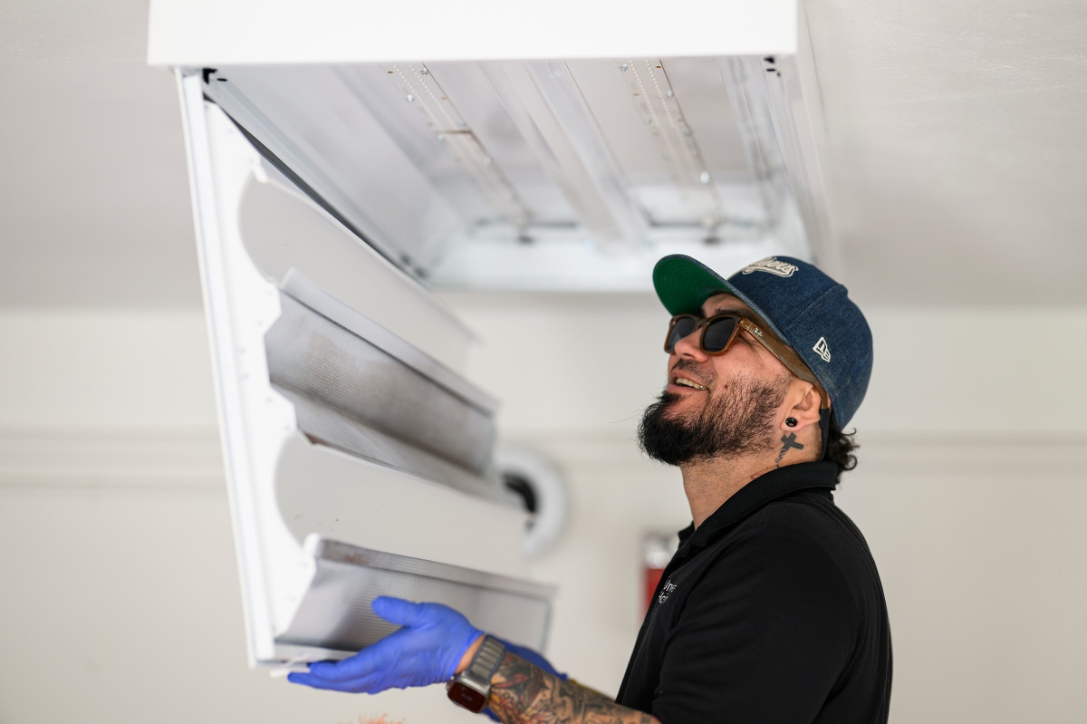Diaz Solano works on a ceiling light fixture in UW–Madison's Slichter Residence Hall. 