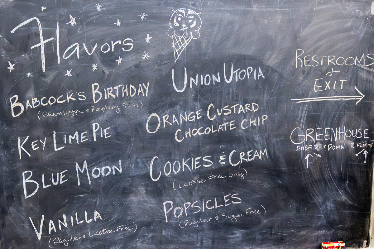 Ice cream flavors are written on a black chalkboard with white chalk.