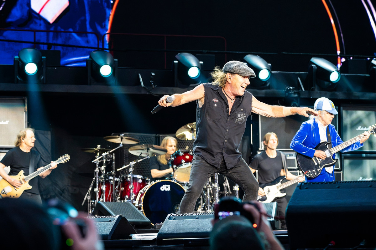 Johnson wears a black Harley-Davidson vest and moves on stage to the music.