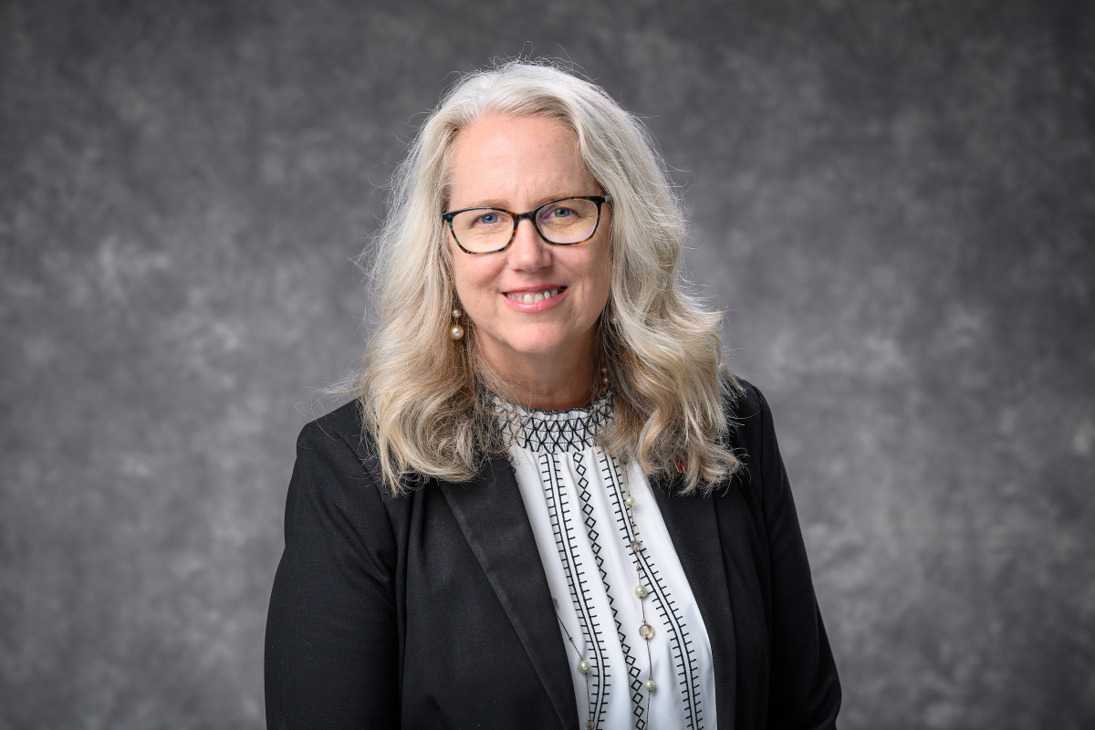 Smiling portrait of Glenda Gillaspy with a neutral gray background.
