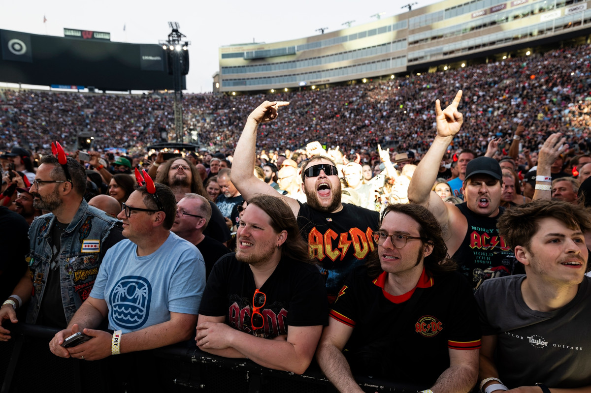 Decked out in AC/DC gear, fans in the crowd cheer