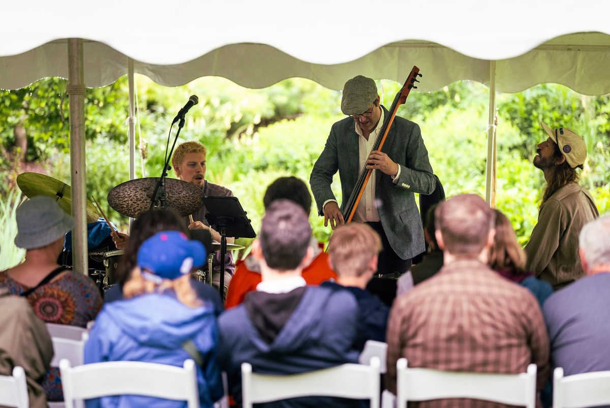 The three members of the jazz trio, Mr. Chair perform in front of a small crowd