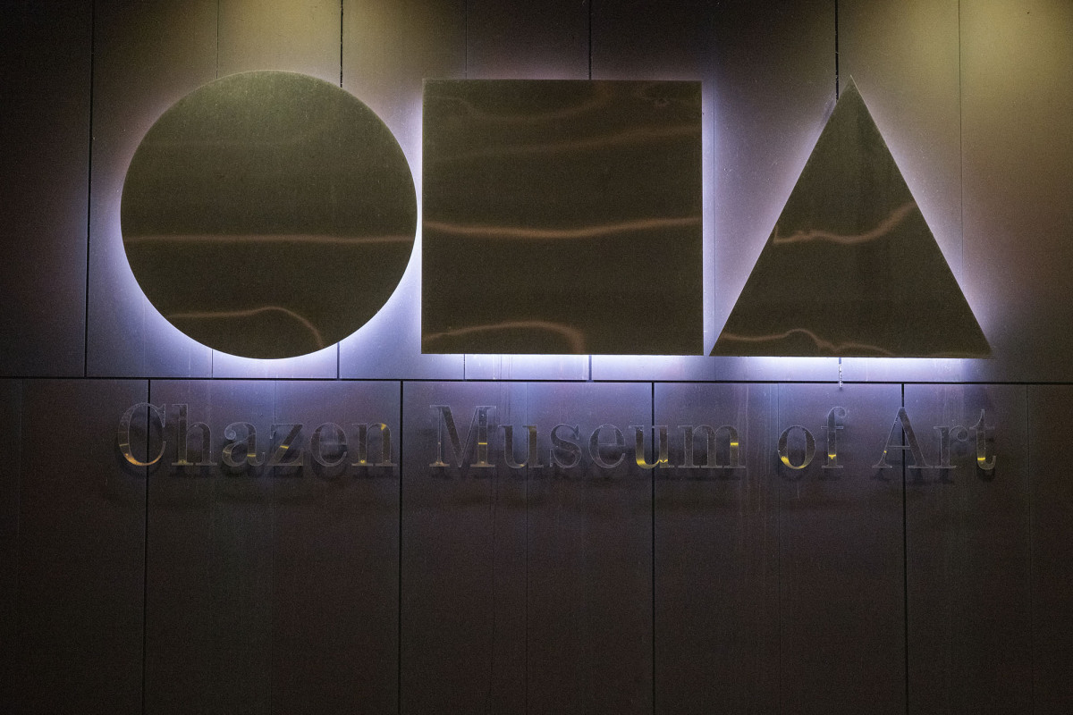 The illuminated Chazen logo on a cement wall