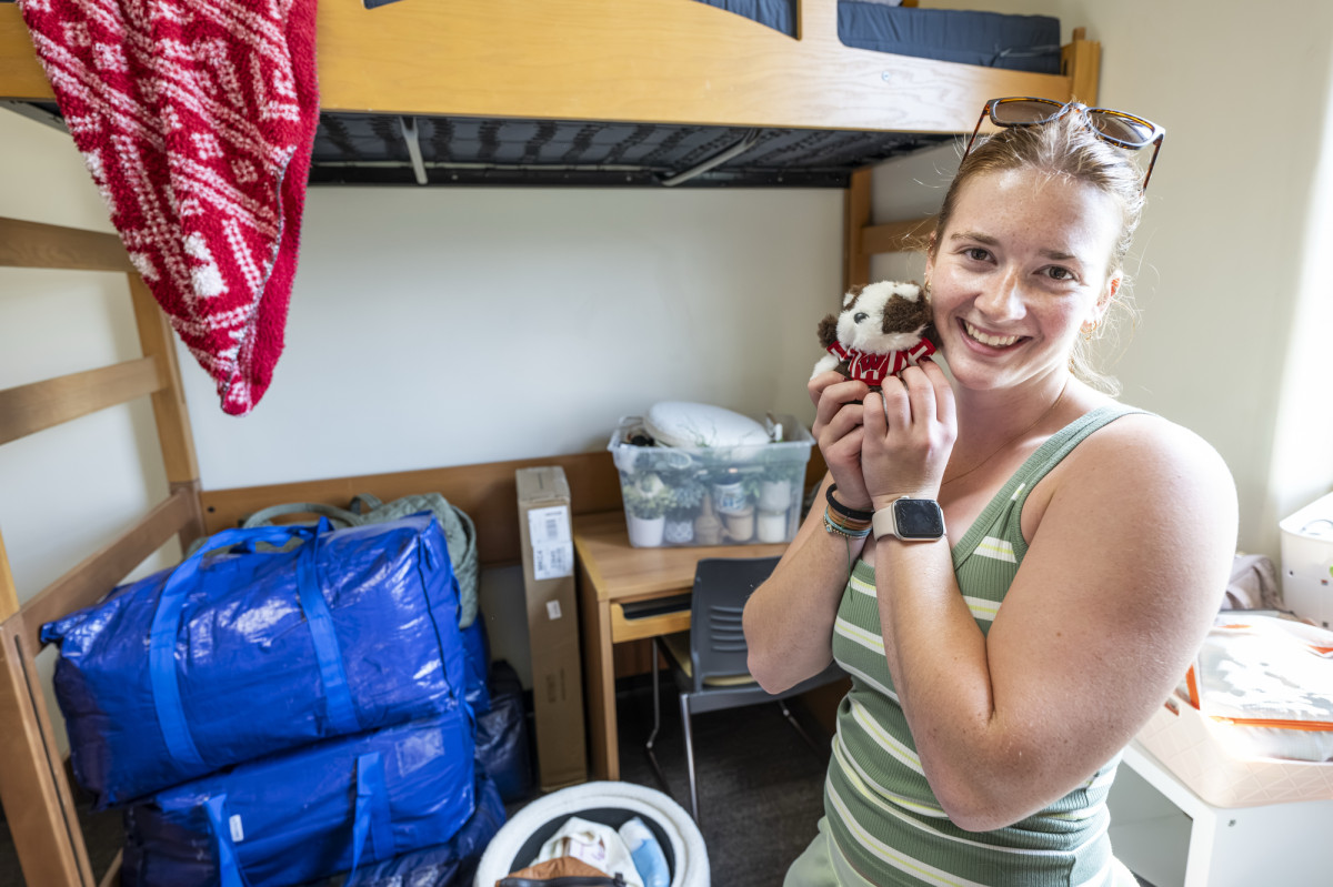 A student snuggles with a miny stuffed animal version of Bucky Badger in her residence hall room.