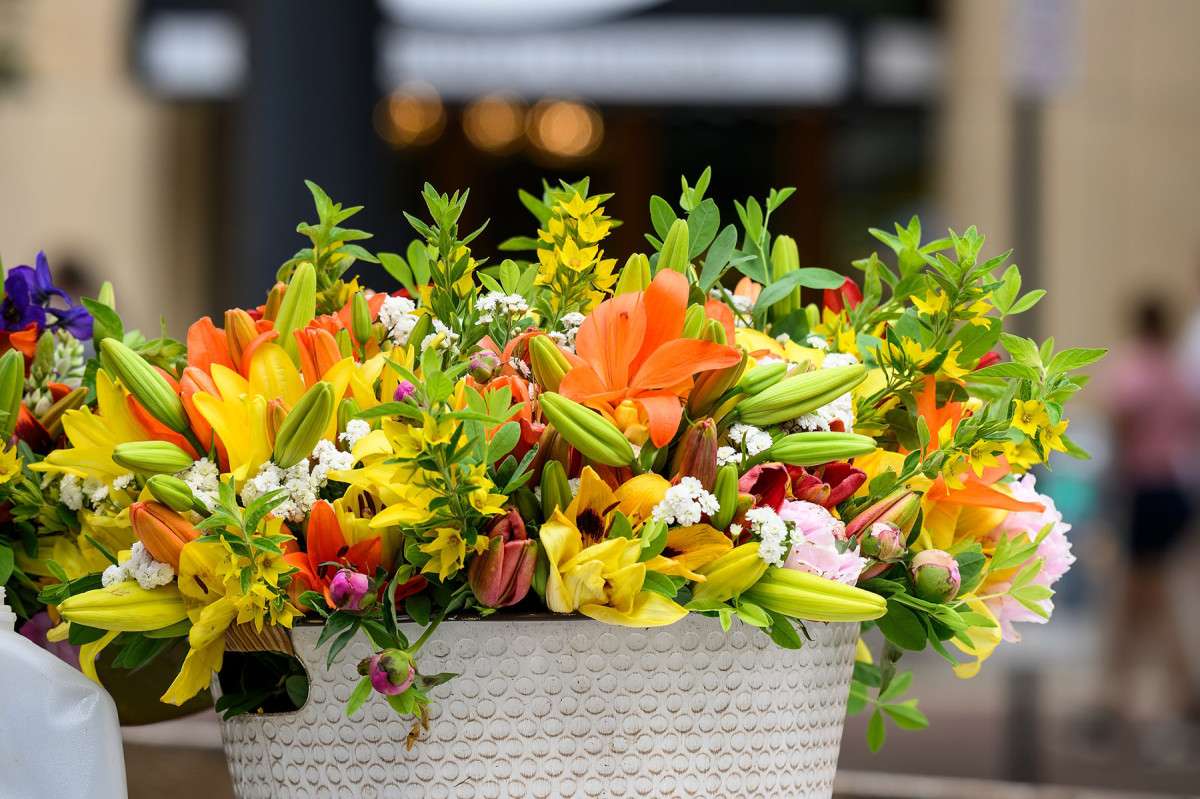 A flower arrangement with yellow and orange lilies