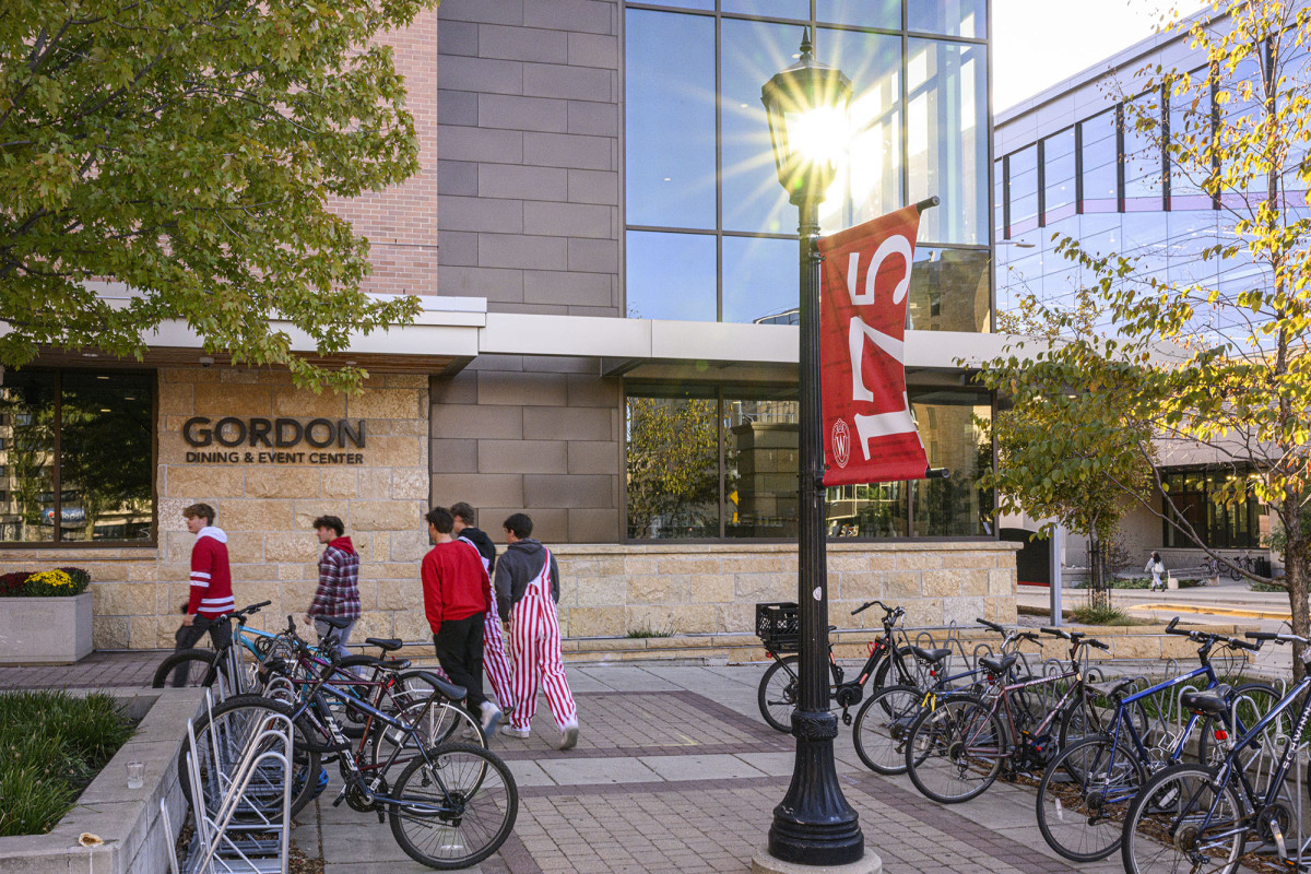 Students wearing Badger gear walk inside Gordon Commons