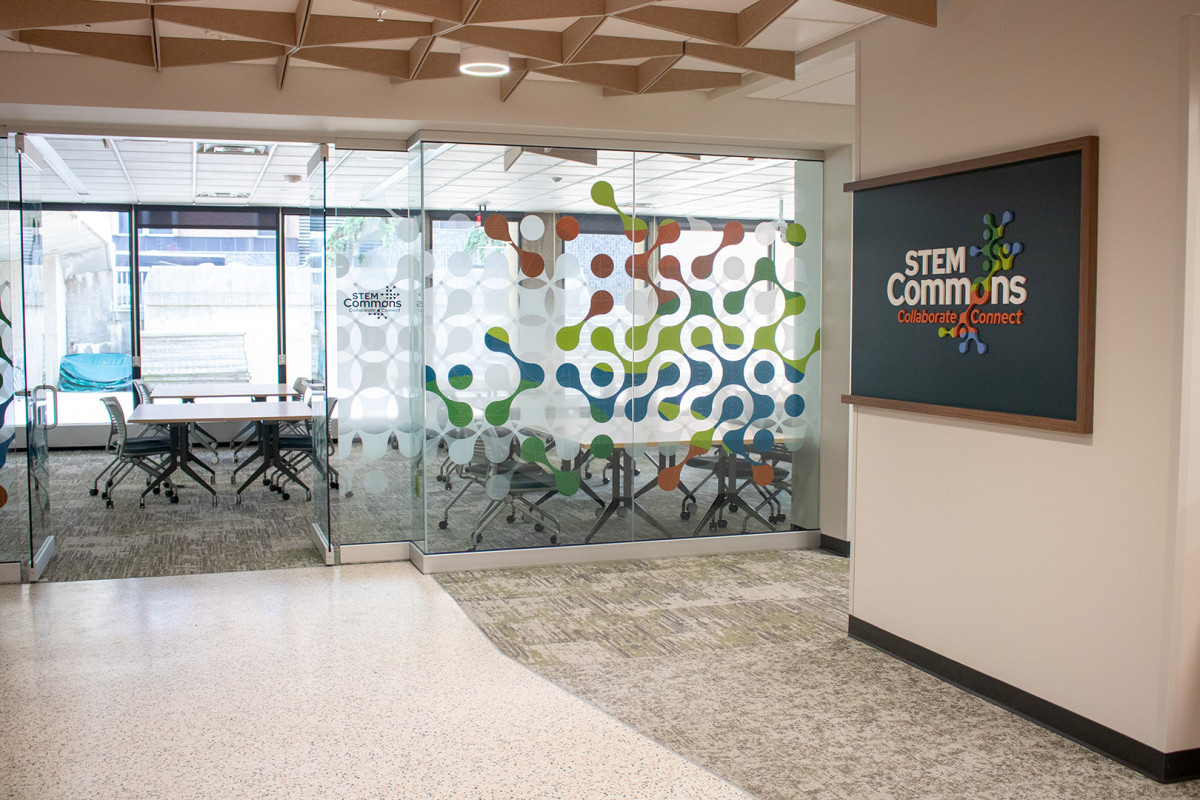 A sign reading "STEM Commons" outside a modern classroom