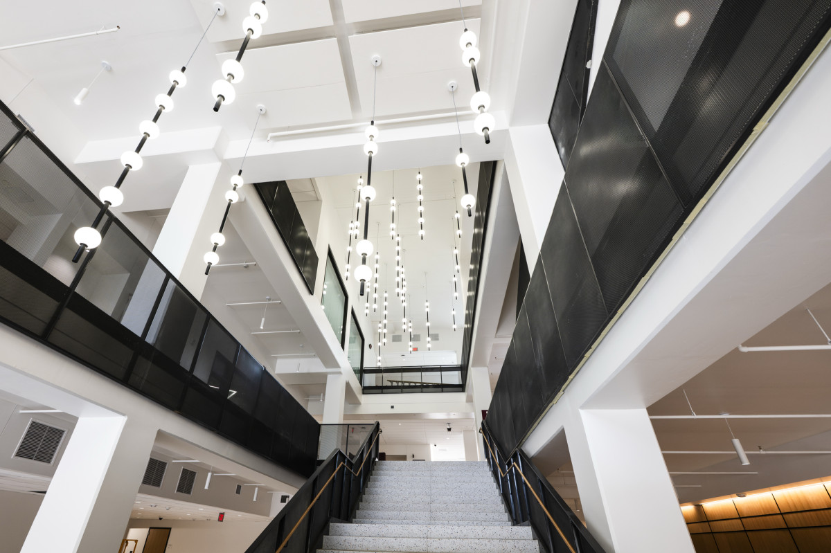 Decorative light fixtures hang from the ceiling, adding visual interest to the bright, modern interior of Irving & Dorothy Levy Hall.P