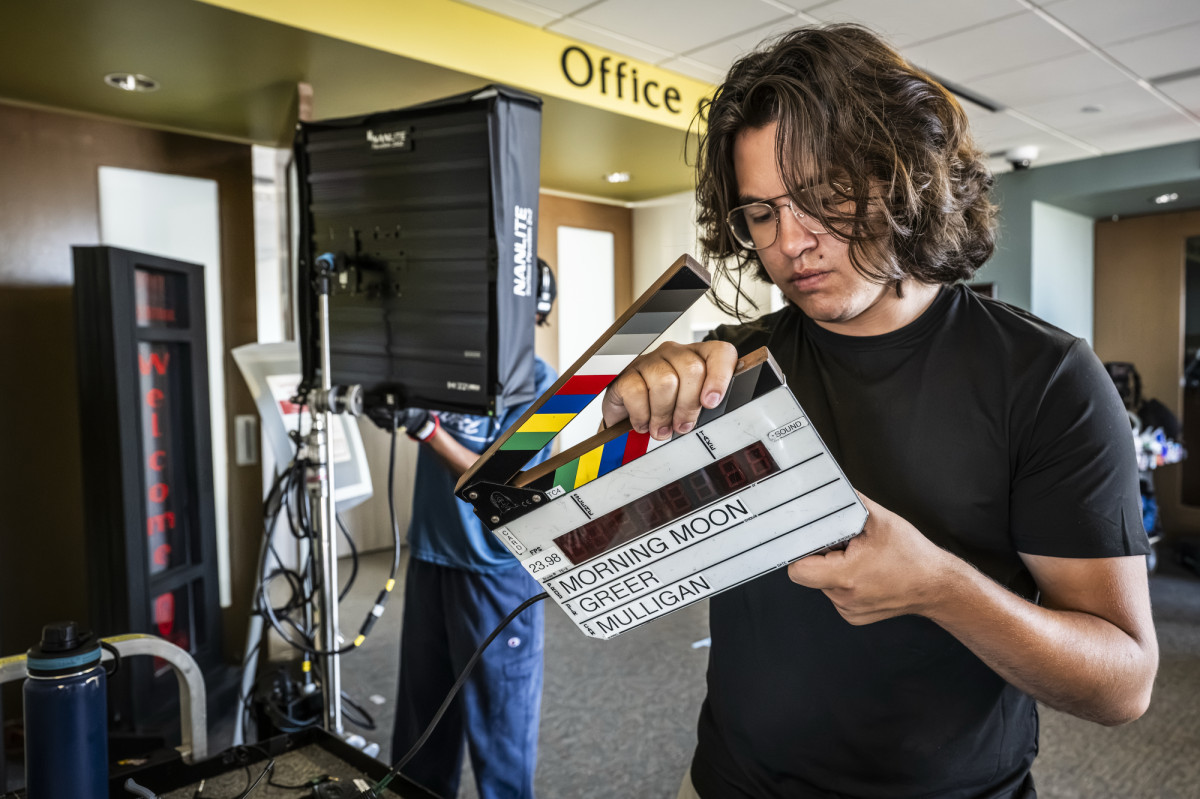 A person holding and looking at a director's clapboard