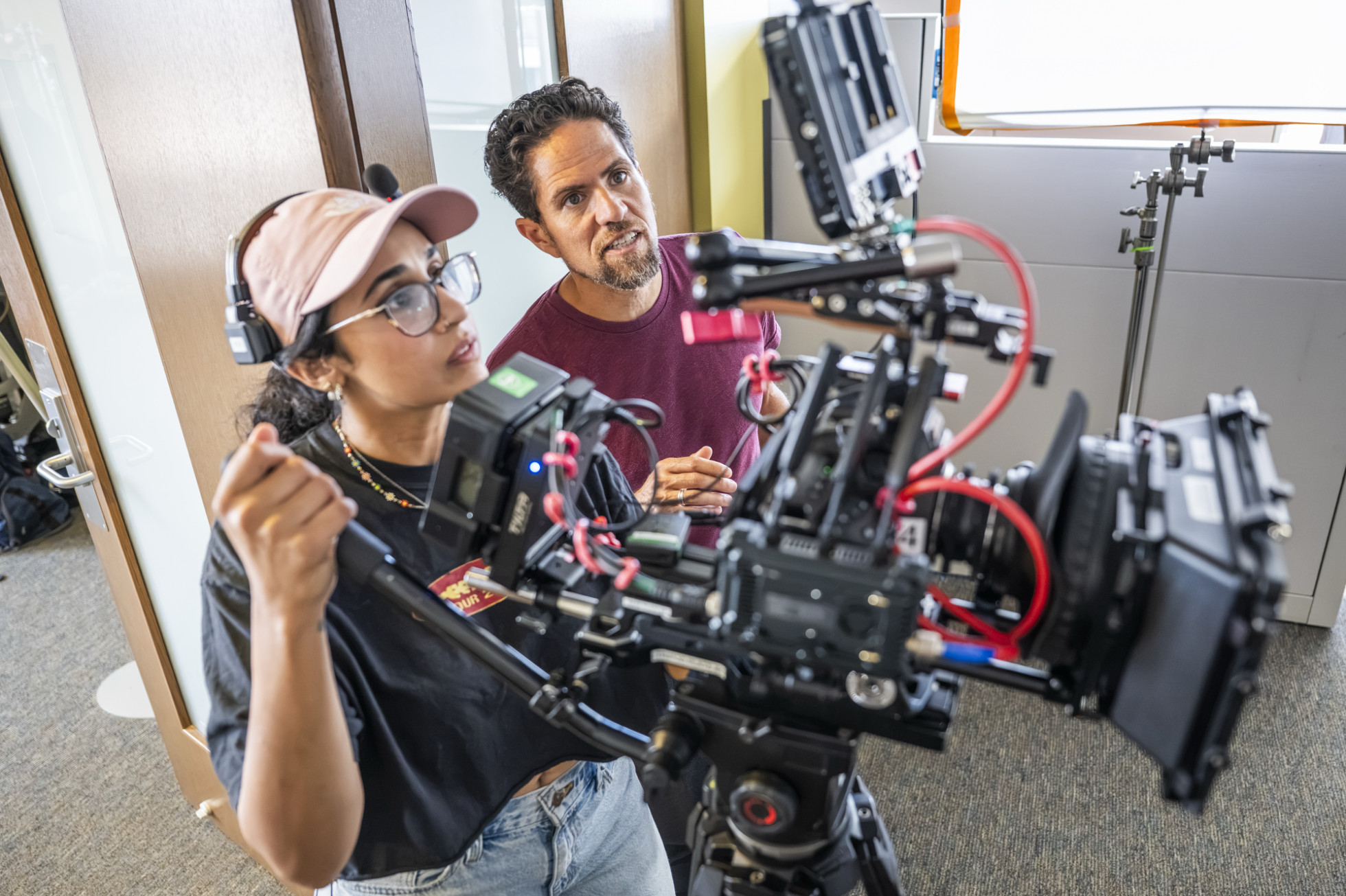 Two people starring intently at a screen of a camera while filming