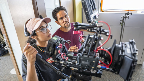 Two people starring intently at a screen of a camera while filming