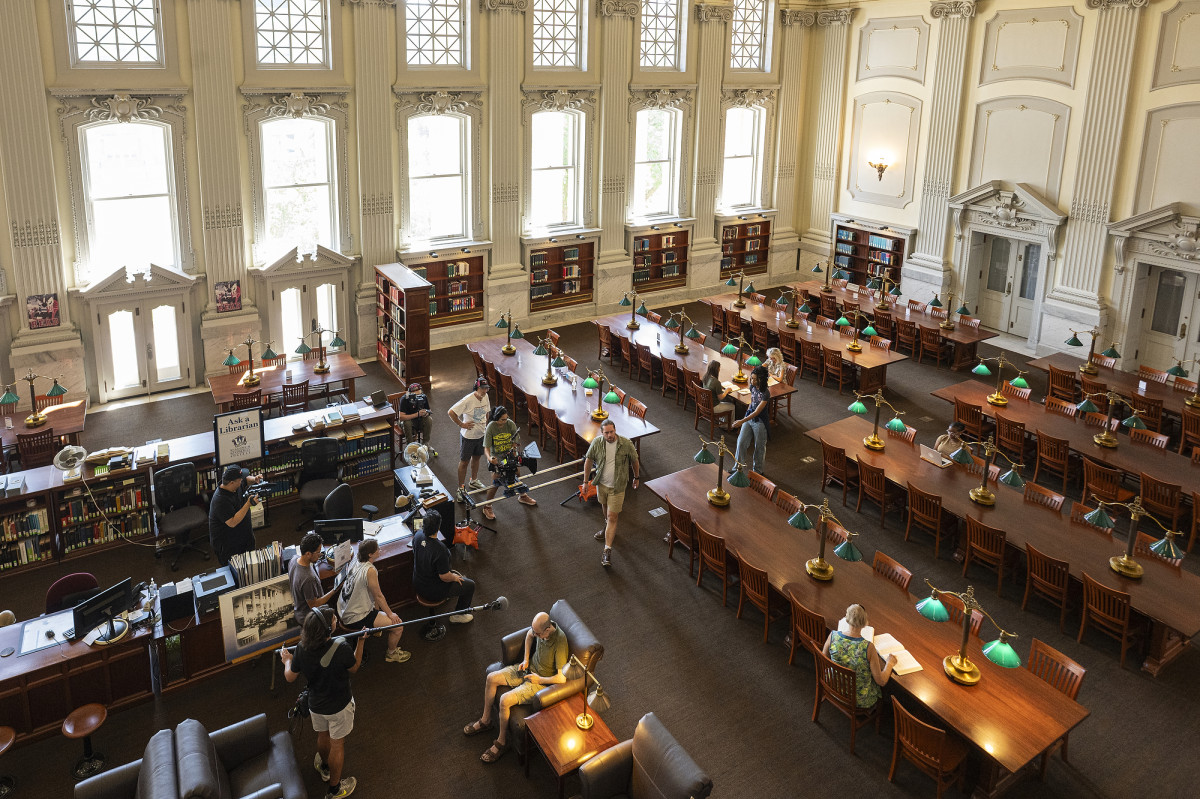 Overhead view of a historic library interior with a film crew shooting a scene