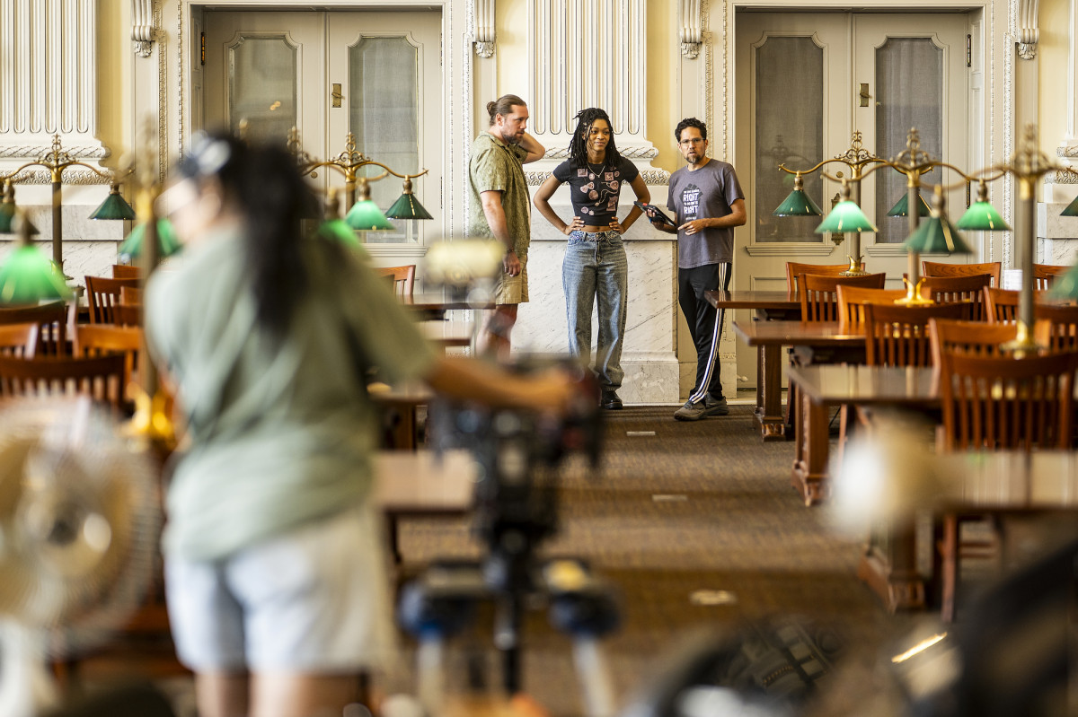 Three people talking while standing in a historic library