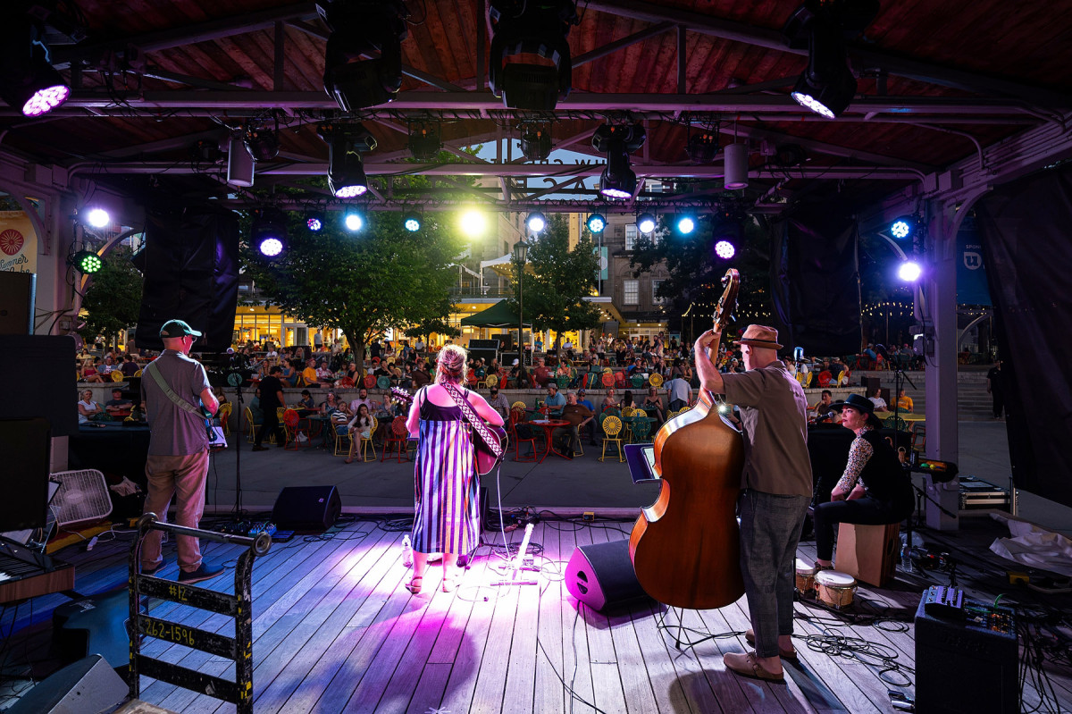 A band performs on the Terrace stage at night under colorful lights