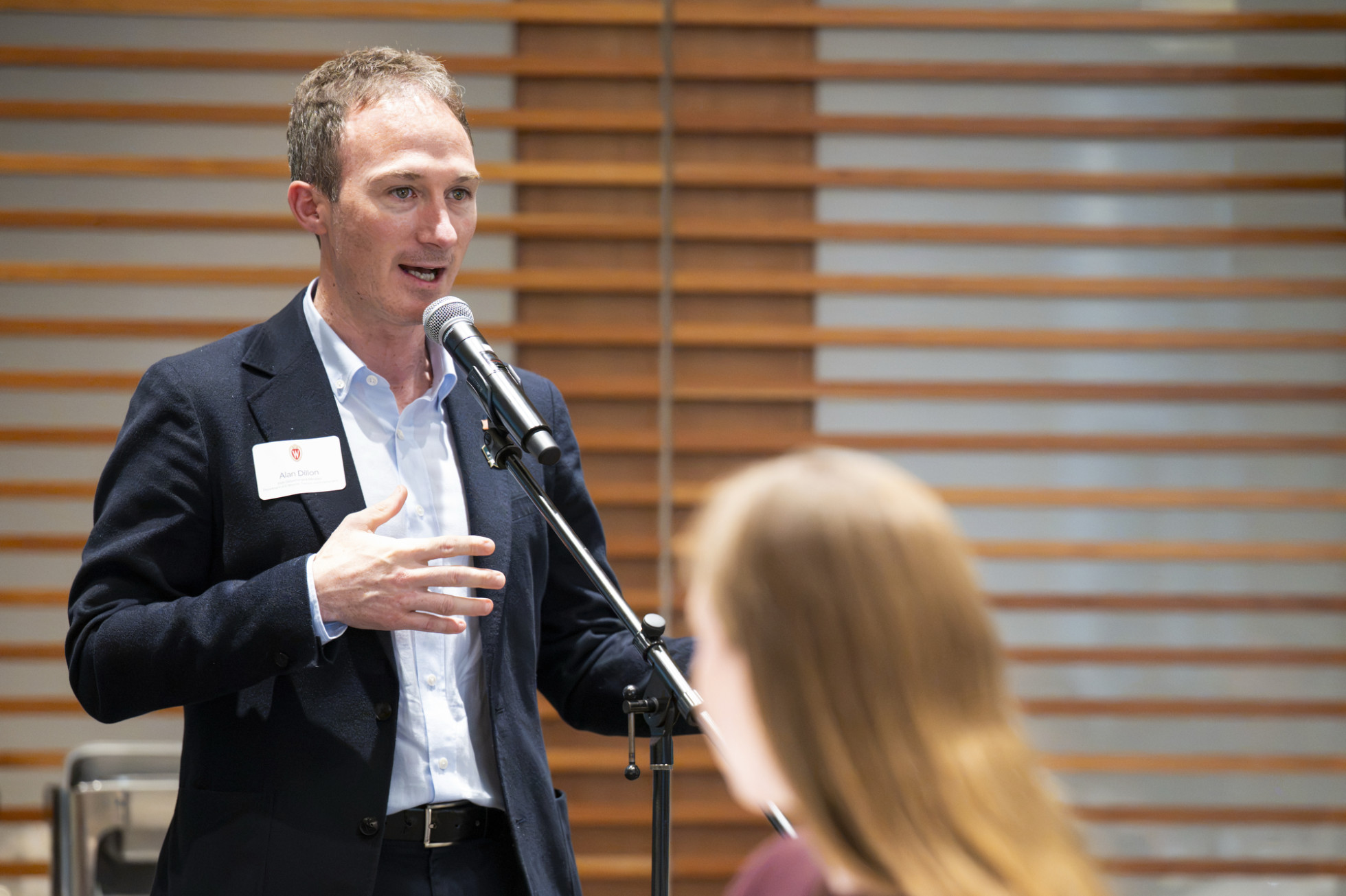 Alan Dillon stands and speaks into a microphone. 