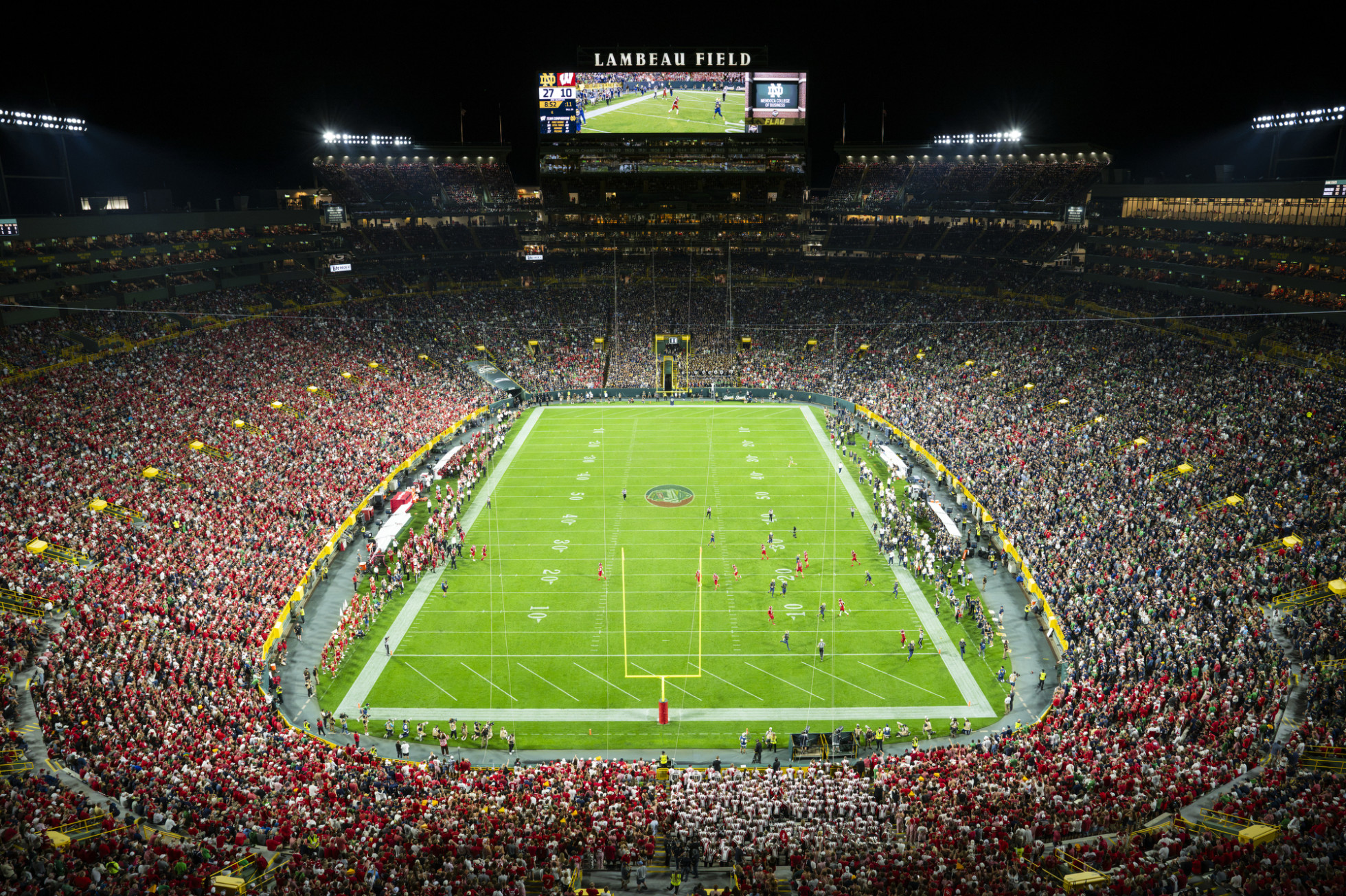 A high-level view of the Lambeau Field, with half of the bowl in red and the other in navy.  