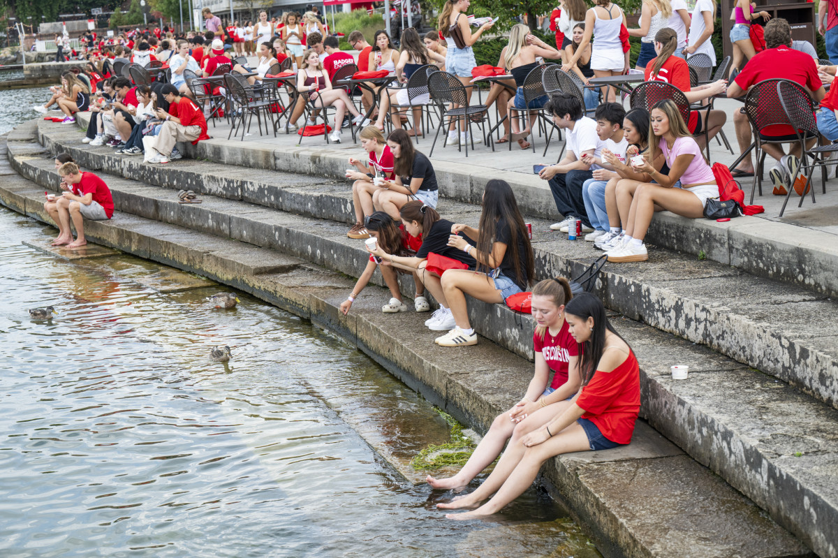 Students sit on the lakeshore steps at the Memorial Union Steps while eating ice cream.