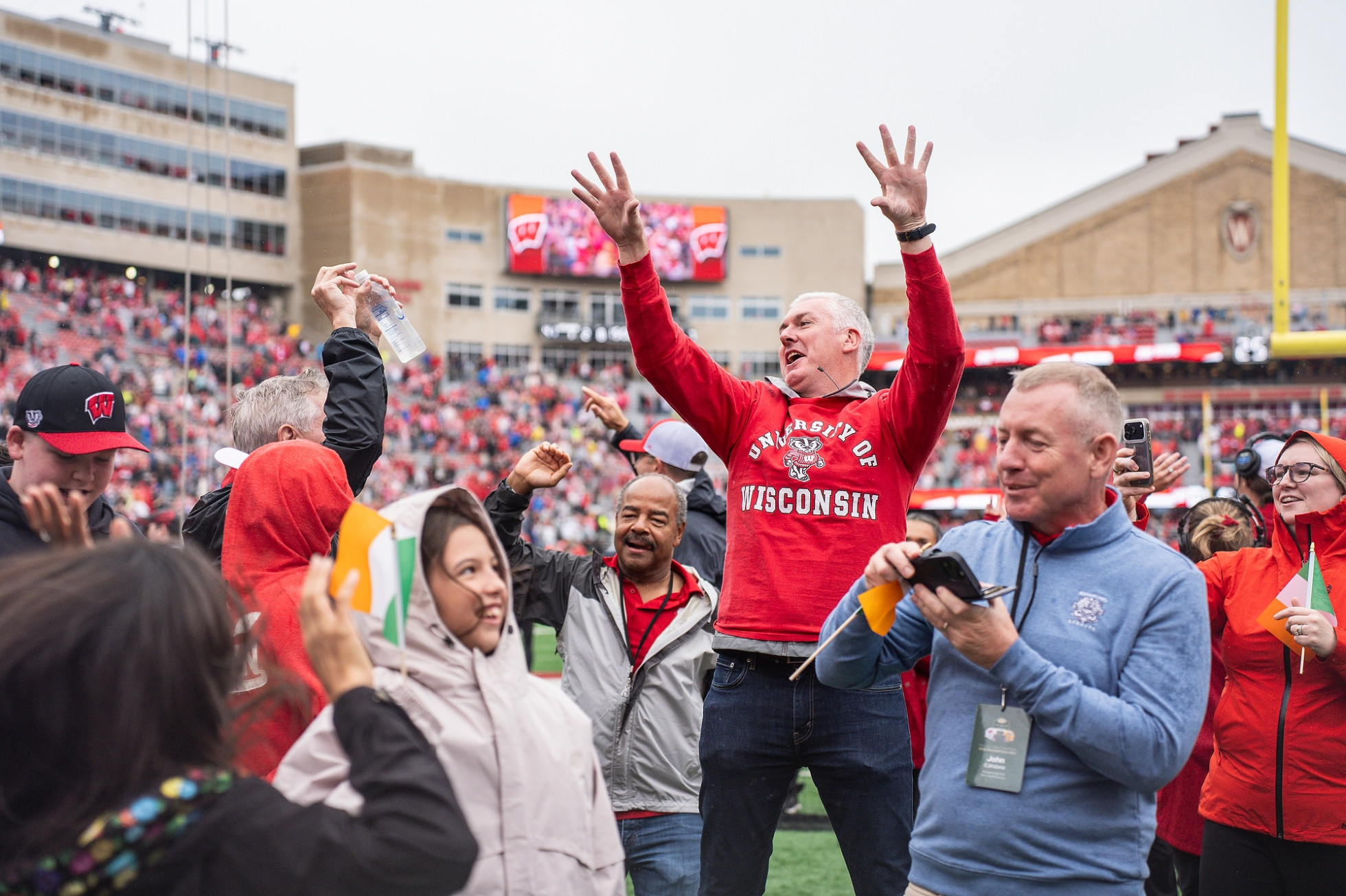 Members of the Irish delegation jump to "Jump Around" on the Camp Randall field.