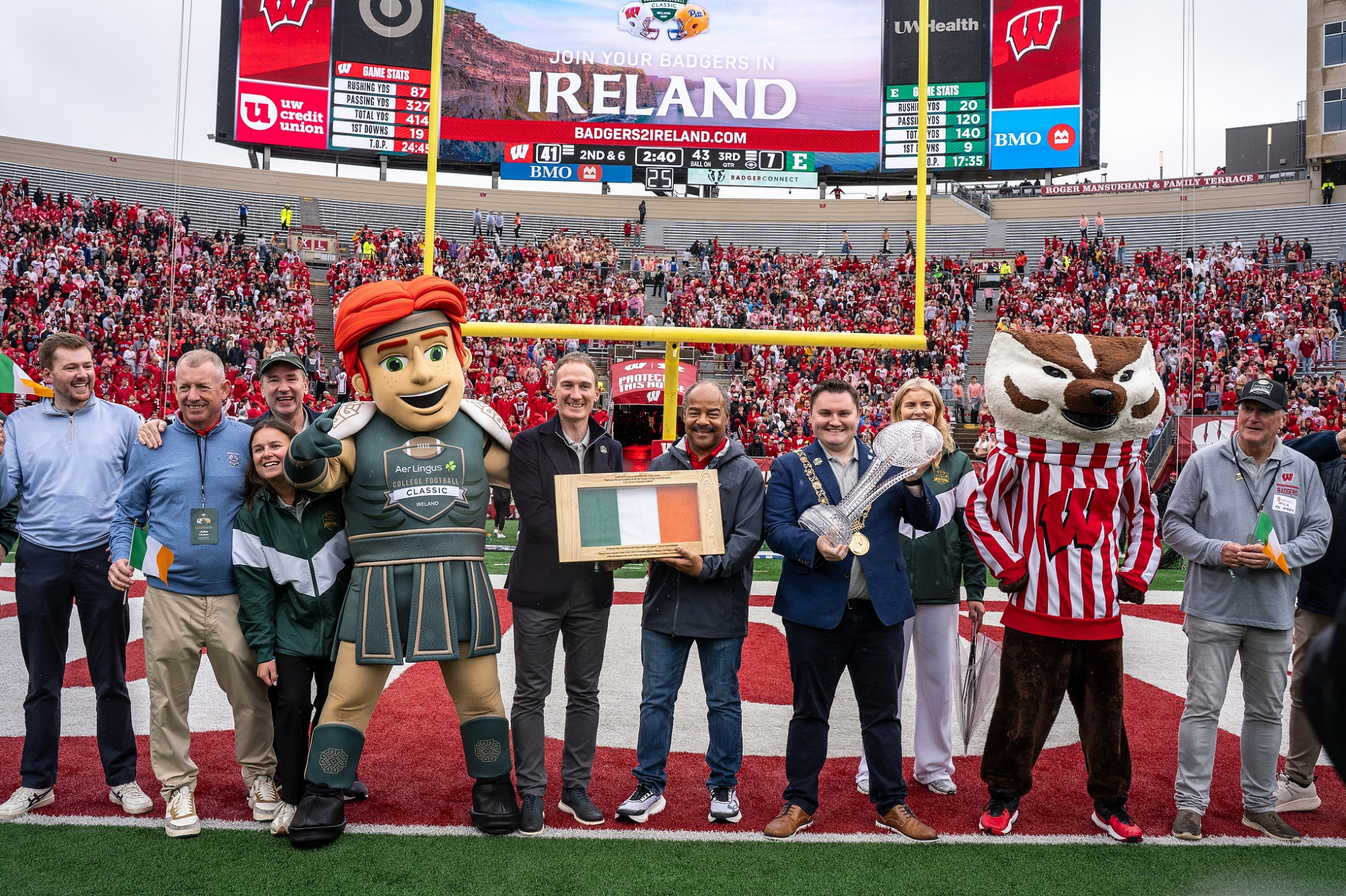 Members of the Irish delegation pose with interim Chancellor Eric Wilcots during a flag presentation on the Camp Randall field.