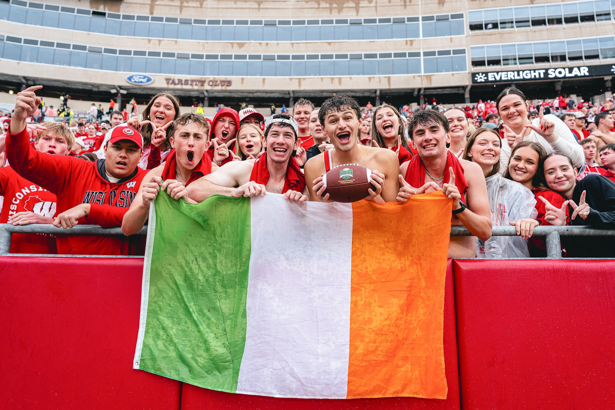 Students at Camp Randall Stadium hold up an Irish flag.