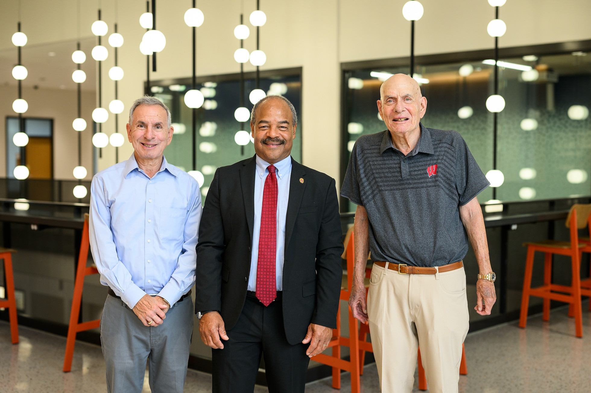 Three men stand for a photo in the newly opened Levy Hall.